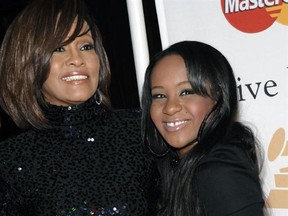 FILE - In this Feb. 12, 2011, file photo, singer Whitney Houston, left, and daughter Bobbi Kristina Brown arrive at an event in Beverly Hills, Calif. The daughter of late singer and entertainer Whitney Houston was found Saturday, Jan. 31, 2015, unresponsive in a bathtub by her husband and a friend and taken to an Atlanta-area hospital. The incident remains under investigation. (AP/Dan Steinberg, File)