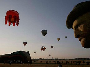Hot air balloons dot the sky at the start of the 19th Philippine Hot Air Balloon festival Thursday, Feb. 12, 2015 at Clark Special Economic Zone, a former U.S. Air Force base in Pampanga province, north of Manila, Philippines. Now on its 19th year, the hot air balloon festival features a total of 32 hot air balloons participating from all over the world. (AP Photo/Bullit Marquez)