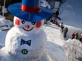 Almost finished is the giant snowman 'Jakob' on the marketplace in Bischofsgruen, southern Germany, Friday, Feb. 13, 2015. Using construction machinery and shovels, volunteers built a giant snowman for the 30th time at the Fichtelgebirge mountains this year.