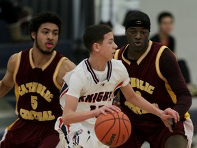 Catholic Central's Raekwon Fazekas, left, and Malique Calloo surround Holy Names' Isiah Byrd in high school basketball Thursday at Holy Names. (NICK BRANCACCIO/The Windsor Star)