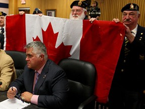 Mike Beale, seated left, and Peter Hrastovec, members of Great Canadian Flag Project listen to questions from City Council to proceed with construction a massive Canadian flag and pole at the foot of Ouellette Avneue, Tuesday February 17, 2015. Behind, local veterans and legion members stand behind the flag project at City Council meeting. (NICK BRANCACCIO/The Windsor Star)r)