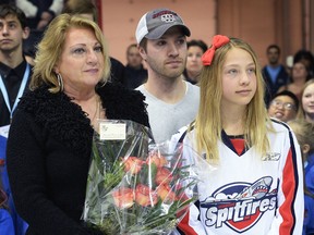 Jane Renaud, from left, her son Remy and daughter Penny participate in a pre-game ceremony to honour Mickey Renaud at the WFCU Centre last year. (DAN JANISSE/The Windsor Star)
