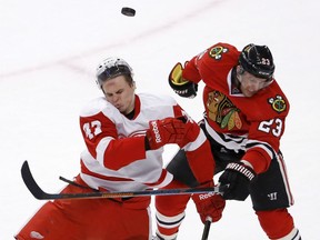 Detroit Red Wings defenceman Alexei Marchenko, left, and Chicago Blackhawks right-winger Kris Versteeg collide after going for a puck during the overtime period Wednesday in Chicago. (AP Photo/Charles Rex Arbogast)