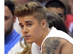 Singer Justin Bieber watches the Los Angeles Clippers play the Oklahoma City Thunder during Game 4 of the Western Conference semifinal NBA basketball playoff series in Los Angeles, May 11, 2014. After months of unusually serene and decent behaviour from Bieber, the nearly 21-year-old pop star's campaign of contrition seemed to launch in earnest last week. THE CANADIAN PRESS/AP/Mark J. Terrill