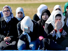 Women mourn for Deah Shaddy Barakat, Yusor Mohammad Abu-Salha and Razan Mohammad Abu-Salha, Thursday, Feb. 12, 2015, in Raleigh, N.C., two days after they were killed in a condominium in Chapel Hill, N.C. Craig Stephen Hicks was charged with three counts of first-degree murder. (AP Photo/The News & Observer, Corey Lowenstein)