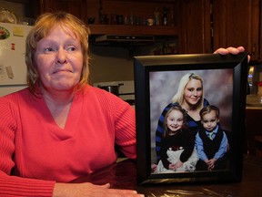 Carmel O'Quinn holds a studio photograph of her daughter Kayla Vaillancourt and grandchildren Miah, 3, and Ethan 2, who were injured in a fire last weekend.  Kayla Vaillancourt is still in hospital, but would like to reach out to Windsor firefighters who save her life.  O'Quinn had a chance to speak with Vaillancourt today, February 19, 2015. (NICK BRANCACCIO/The Windsor Star)