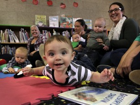 WINDSOR, ONT. September 22, 2014.  Harrison Ross, 7-months, has a happy introduction to reading and books during Baby Storytime at Riverside Branch of Windsor Public Library Monday September 22, 2014. (NICK BRANCACCIO/The Windsor Star) RAISE A READER FEATURE