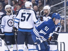 Toronto's Jake Gardiner, right, skates past members of the Winnipeg Jets as they celebrate a goal during the second period Saturday in Toronto. (THE CANADIAN PRESS/Darren Calabrese)