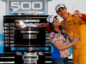 Joey Logano, driver of the #22 Shell Pennzoil Ford, and wife Brittany take a selfie in Victory Lane with The Harley J. Earl Trophy after winning the NASCAR Sprint Cup Series 57th Annual Daytona 500 at Daytona International Speedway on February 22, 2015 in Daytona Beach, Florida.  (Photo by Jerry Markland/Getty Images)