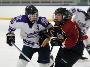 Assumption's Christian Wrona, left, battles with Leamington's Jake Lewsaw during the WECSSAA boys hockey game at Adie Knox Arena Tuesday. (JASON KRYK/The Windsor Star)