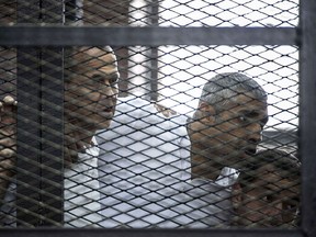A file picture taken on June 23, 2014 at the police institute near Cairo's Tora prison, shows Al-Jazeera news channel's Australian journalist Peter Greste (L) and his colleagues, Egyptian-Canadian Mohamed Fadel Fahmy (C) and Egyptian Baher Mohamed, listening to the verdict inside the defendants cage during their trial. Egypt freed and deported Peter Greste on February 1, 2015 after more than 400 days in detention, following global condemnation of his jailing on charges of backing the Muslim Brotherhood. AFP PHOTO / KHALED DESOUKIKHALED DESOUKI/AFP/Getty Images