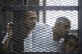 A file picture taken on June 23, 2014 at the police institute near Cairo's Tora prison, shows Al-Jazeera news channel's Australian journalist Peter Greste (L) and his colleagues, Egyptian-Canadian Mohamed Fadel Fahmy (C) and Egyptian Baher Mohamed, listening to the verdict inside the defendants cage during their trial. Egypt freed and deported Peter Greste on February 1, 2015 after more than 400 days in detention, following global condemnation of his jailing on charges of backing the Muslim Brotherhood. AFP PHOTO / KHALED DESOUKIKHALED DESOUKI/AFP/Getty Images