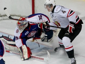 Owen Sound's Thomas Schemitsch, right, deflects a shot in front of Windsor goaltender Brendan Johnston at the WFCU Centre Thursday. (NICK BRANCACCIO/The Windsor Star)