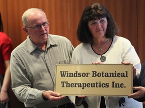 Donna and Dave Couvillon, parents of the late Kevin Couvillon display a Windsor Botanical Therapeutics Inc. sign during a presentation of a progress report on The Kevin Couvillon Research Project on the anti-cancer effects of dandelion root extract.  The event was at the University of Windsor on February 17, 2015. (JASON KRYK/The Windsor Star)