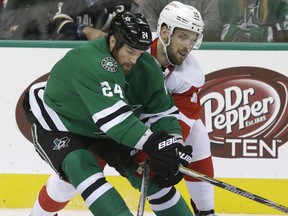 Dallas defenceman Jordie Benn, left, is checked by Detroit's Riley Sheahan during the first period Saturday in Dallas. (AP Photo/LM Otero)