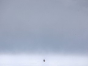 Two people walk through drifting snow towards the Kingsville Ferry Dock after ice fishing on Lake Erie, Saturday, Feb. 14, 2015.  (DAX MELMER/The Windsor Star)