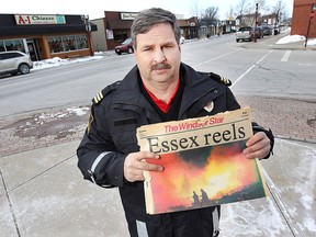 Essex firefighter Rick Bonneau was one of the first on the scene when there was a big explosion in downtown Essex, ON. 35 years ago. He is pictured Friday, Feb. 13, 2015, with a copy of The Windsor Star published Feb. 14, 1980. He is one of the firemen silhouetted against the flames.  (DAN JANISSE/The Windsor Star)