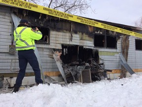 An investigator with Windsor fire photographs the scene of a blaze at 6 Marlin Ct. in Windsor, Ont. Tuesday, Feb. 17, 2015. (Twitpic: DAN JANISSE/The Windsor Star)