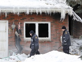Investigators with the Office of the Ontario Fire Marshal investigate the scene of a house fire at 650 Laurier Dr., Feb. 16, 2015.  (DAX MELMER/The Windsor Star)