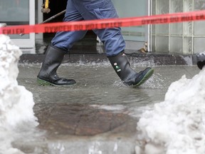 Windsor Fire and Rescue work to shut off a significant water leak at 540 Ouellette Ave., Sunday, Feb. 22, 2015.  Water could be seen streaming out of the lobby onto the street, as well as streaming down the walls of the Manchester Pub next door.  (DAX MELMER/The Windsor Star)