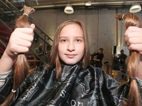 Julian Brink, 10, holds up the hair he had cut off at Cabello Hair, Saturday, Feb. 14, 2015.  Julian is donating his hair to the Cancer Society.  His idea for the donation came after watching a documentary about kids with cancer in which most of the kids said they wish they had their hair back.  (DAX MELMER/The Windsor Star)