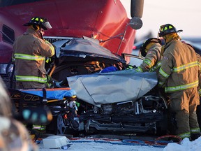 Emergency crews work to remove a woman from a car after being involved in a three-car motor vehicle accident involving a car, a transport truck and a minivan on Manning Road north of Baseline Road, Monday, Feb. 23, 2015.  (DAX MELMER/The Windsor Star)