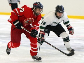 Brennan's Chase Kavanaugh, left, cuts around Belle River's Matt Walker at Lakeshore Arena in Lakeshore Tuesday. (TYLER BROWNBRIDGE/The Windsor Star)