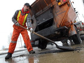 Mark Lockwood fills potholes along Wyandotte Street East in Windsor on Wednesday, February 11, 2015. Crews were out tackling the worst potholes in hopes of minimizing repairs to cars. (TYLER BROWNBRIDGE/The Windsor Star)