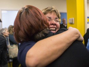Wanda Morris (right), CEO of Dying with Dignity, embraces a colleague at the group's offices in Toronto on Friday, February 6, 2015 after the Supreme Court ruled that Canadian adults have the right to a doctor's help in dying. THE CANADIAN PRESS/Chris Young