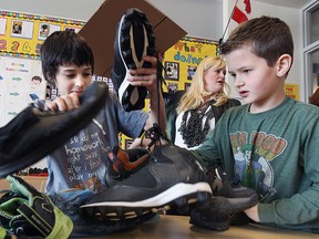 Students and staff at Dr. David Suzuki School Public School in Windsor, ON. have started collecting shoes for needy people in Haiti. Teacher Kelly McKay who is organizing the project is shown with Cody Renaud, 9, (L) and Evan Head, 9, sorting through some of the shoes at the school on Tuesday, Feb. 10, 2015.  (DAN JANISSE/The Windsor Star)