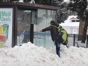 A man maneuvers over a snow bank to reach a bus shelter on Wyandotte Ave. W. on Tuesday, Feb. 3, 2015, in Windsor, ON. (DAN JANISSE/The Windsor Star)
