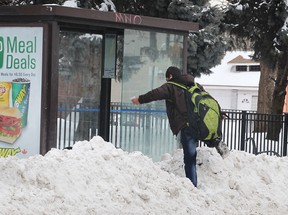 A man maneuvers over a snow bank to reach a bus shelter on Wyandotte Ave. W. on Tuesday, Feb. 3, 2015, in Windsor, ON. (DAN JANISSE/The Windsor Star)