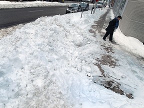 Ruth Warrington walks around a snow wall as she navigates the sidewalks in Windsor on Tuesday, February 3, 2015.  (TYLER BROWNBRIDGE/The Windsor Star)
