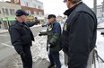 Bylaw officer Bill Tetler (left) and Bart Pogorzelski (right) talk to the parking lot owner Tom Alexopoulos during a crackdown on those who have not cleared their sidewalks in Windsor on Wednesday, February 4, 2015.  (TYLER BROWNBRIDGE/The Windsor Star)