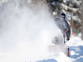 Snow is blown into the air while being cleared with a snowblower on Tuscarora St. after a winter storm dumped over 30cm of snow in the Windsor region, Monday, Feb. 2, 2015. (DAX MELMER/The Windsor Star)