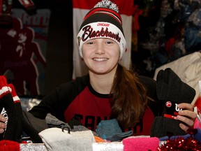 Ninth grade philanthropist Sarah Lewis hands out socks and gloves at Street Help in Windsor, Thursday, February 12, 2015. In its eighth year Lewis' campaign 'Socks Warm Your Heart' provided more than 500 pairs of socks and a cash donation to help the homeless. (RICK DAWES/The Windsor Star)