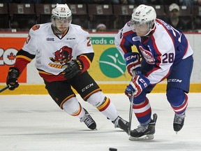 Windsor's Slater Doggett brings the puck up the ice against Belleville's Niki Petti, left, as the Windsor Spitfires host the Belleville Bulls in OHL action at the WFCU Centre, Sunday, Feb. 1, 2015.  (DAX MELMER/The Windsor Star)