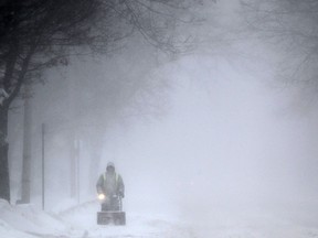 Bob Scott clears snow from the road with a snowblower on the 1900 block of Pillette Rd., as a winter storm with near white-out conditions descends into the Windsor and Essex County region, Sunday, Feb. 1, 2015.  (DAX MELMER/The Windsor Star)
