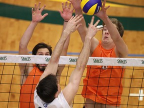 Mark Kaveckas, left, and Bryce Marcussen, right, of the Mohawk Mountaineers attempt to block a tip from Niagara College's Aaron Vanderlugt during OCAA volleyball championships at the St. Clair College SportsPlex in Windsor on Friday, February 27, 2015.       (TYLER BROWNBRIDGE/The Windsor Star)