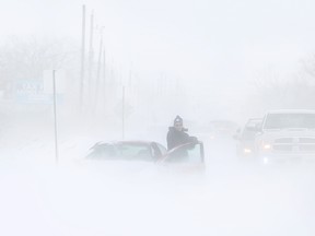 WINDSOR, ONT., (14/02/15) -- A driver gets out of his car after a five-car motor vehicle accident backed up traffic on County Rd. 42, Saturday, Feb. 14, 2015.  County Rd. 42 was later closed by Windsor Police due to drifting snow that was causing treacherous driving conditions.  (DAX MELMER/The Windsor Star)
