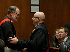The Honourable Mr. Justice Kirk W. Munroe is congratulated by Justice Bruce Thomas after receiving judges robes during his official Swearing-in ceremony as Judge of the Superior Court of Justice in Windsor Monday, March 2, 2015. (NICK BRANCACCIO/The Windsor Star)