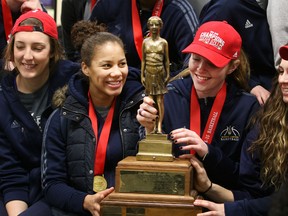 Tessa Kreiger, from left, Korissa Williams, Courtney VandeBovenkamp, Kristine Lalonde and Carly Steer pose with the Bronze Baby Trophy after the CIS champion Windsor Lancers arrived at the Windsor International Airport Monday night. (DAX MELMER/The Windsor Star)