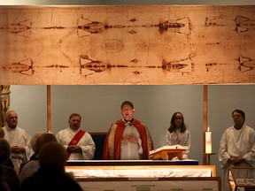 Rev. Gregory Bonin says mass under the Replica of the Shroud of Turin at Most Precious Blood Church Tuesday March 10, 2015.  The Shroud of Turin replica, a 14-foot linen cloth bearing image of what millions believed to be Jesus Christ is part of Man of the Shroud Exhibit at Most Precious Blood, 1947 Meldrum Road, Windsor. (NICK BRANCACCIO/The Windsor Star)