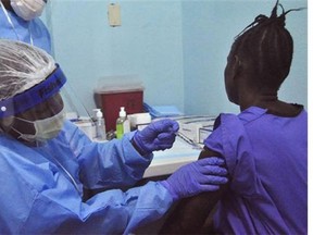 A woman is injected by a health care worker, left, as she takes part in an Ebola virus vaccine trial, at one of the largest hospital's Redemption hospital in Monrovia, Liberia, Monday, Feb. 2, 2015. (AP Photo , Abbas Dulleh)
