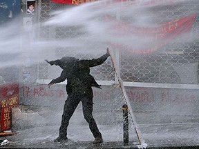 Turkey
A protester holds a plank to hide from a police water cannon on March 11, 2015 in Istanbul, during clashes following a protest in memory of a teenager killed in 2013 anti-government demonstrations and whose death has become a rallying cause for opponents of the Turkish president. The protesters were marking the first anniversary of the death of Berkin Elvan who died on March 11, 2014, after spending 269 days in a coma due to injuries sustained when he was hit by a tear gas canister fired by police in the mass protests of early summer 2013.