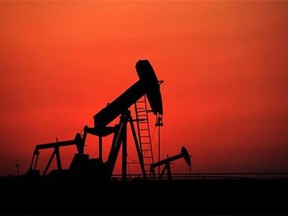 Oil pumps work at sunset on Sept. 11, 2013, in the desert oil fields of Sakhir, Bahrain. Slumping oil prices will cast a shadow on the World Heavy Oil Congress this week in Edmonton. THE CANADIAN PRESS/AP, Hasan Jamali