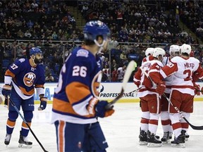 New York Islanders defenseman Brian Strait (37) and center Tyler Kennedy (26) watch Detroit Red Wings right wing Luke Glendening (41), left wing Drew Miller (20) and others celebrate Miller's goal in the first period of an NHL hockey game on Sunday, March 29, 2015, in Uniondale, N.Y. (AP Photo/Kathy Kmonicek)