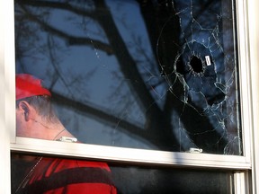 Gerold Prentice, 27, left, was shaken after his double pane front window at 908 Albert Road was broken with a hole about the size of a golf ball Wednesday March 11, 2015.  Windsor Police attended the scene but no evidence of firearms was found. (NICK BRANCACCIO/The Windsor Star)