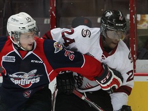 Spits Graeme Brown, left, and Guelph Storm Givani Smith in close quarters during OHL action from WFCU Centre Thursday March 12, 2015.  (NICK BRANCACCIO/The Windsor Star)