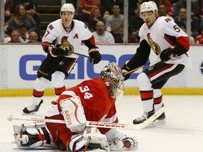 Detroit goalie Petr Mrazek, centre, makes a save with Ottawa's Kyle Turris, left, and Cody Ceci looking for a rebound Tuesday at Joe Louis Arena. (AP Photo/Paul Sancya)